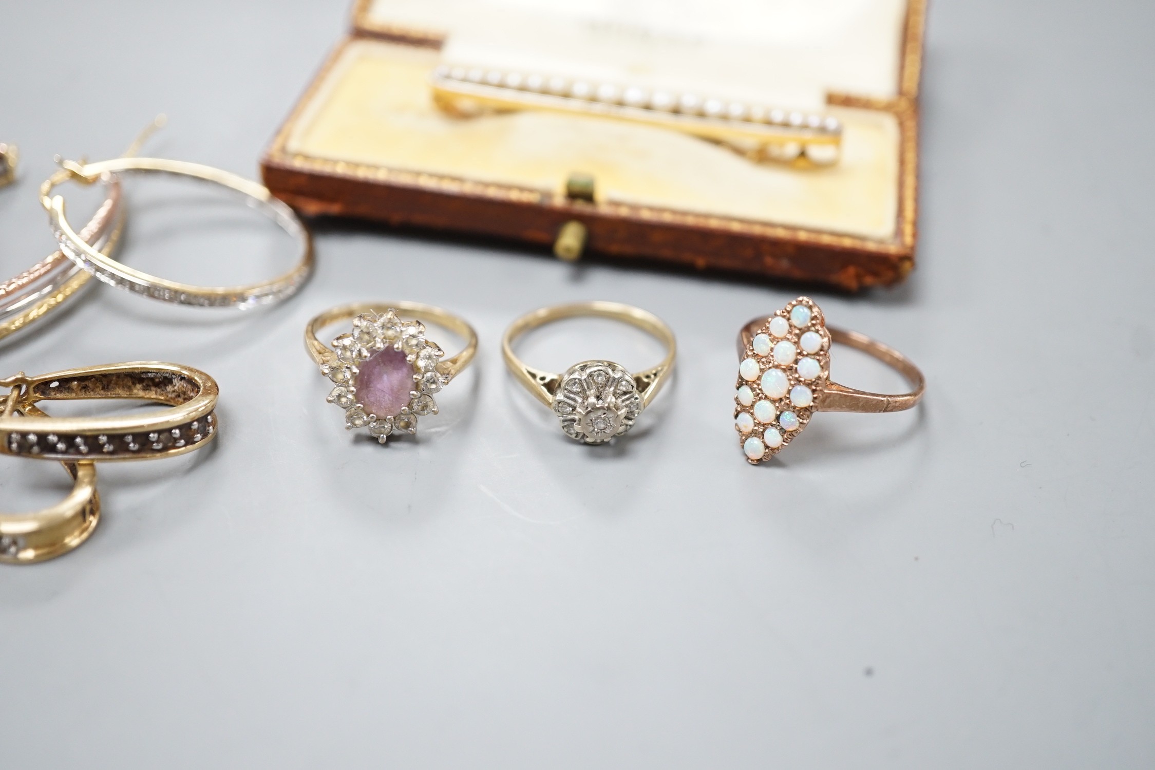 Six assorted modern 9ct gold and gem set rings, including white opal cluster and amethyst and diamond chip, a yellow metal and rose cut three stone garnet set ring, two pairs of modern 9ct gold earrings, including diamon